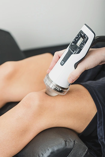Shockwave therapy treatment being applied to a patient's knee.
