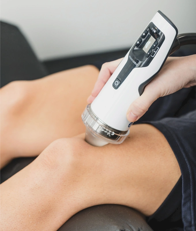 Shockwave therapy treatment being applied to a patient's knee.